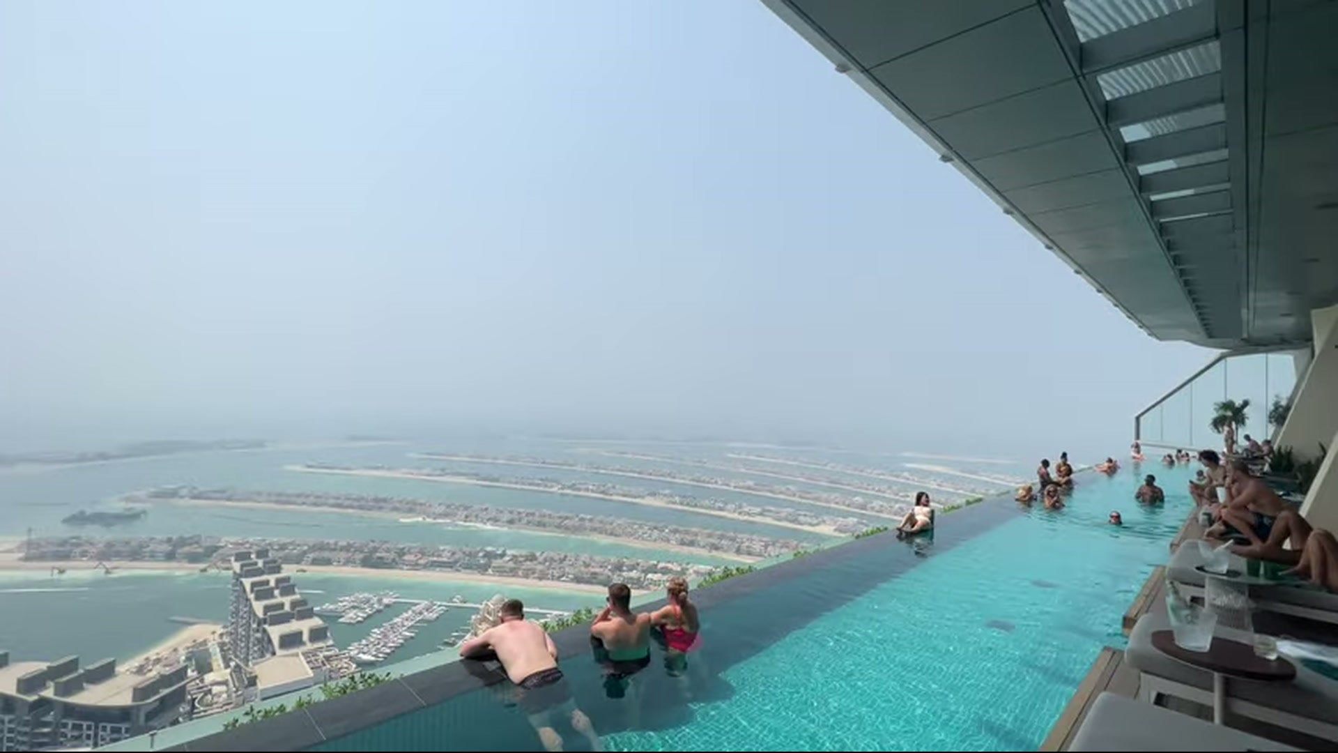 Wide infinity pool scene with guests overlooking Palm Jumeirah in Dubai